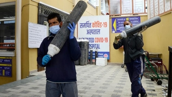 Health workers carrying oxygen cylinders from a store in a hospital in Shimla. (Deepak Sansta/HT File Photo)