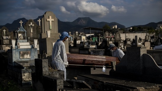 Cemetery workers carrying a coffin at the Inhauma cemetery in Rio de Janeiro, Brazil on June 18. The Covid-19 toll is three times the number of people killed in traffic accidents around the globe every year. It is about equal to the population of Los Angeles or the nation of Georgia. It is equivalent to more than half of Hong Kong or close to 50% of New York City.(Bruna Prado / AP)