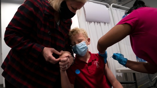 Heather Haworth (L), holds the hand of her 12-year-old son Jeremy as he receives the first dose of the Pfizer Covid-19 vaccine in Santa Ana, California on May 13. The variants, uneven access to vaccines and the relaxation of precautions in wealthier countries are “a toxic combination that is very dangerous,” warned Ann Lindstrand, a top immunization official at the World Health Organization.(Jae C. Hong / AP)