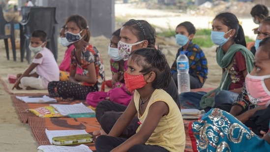 Students from a slum area attend an open-air tuition class at Panchsheel Shikshan Sansthan, at Yamuna Khadar Mayur Vihar, in New Delhi, June 10, 2021. (PTI) Students from a slum area attend an open-air tuition class at Panchsheel Shikshan Sansthan, at Yamuna Khadar Mayur Vihar, in New Delhi, June 10, 2021. (PTI)