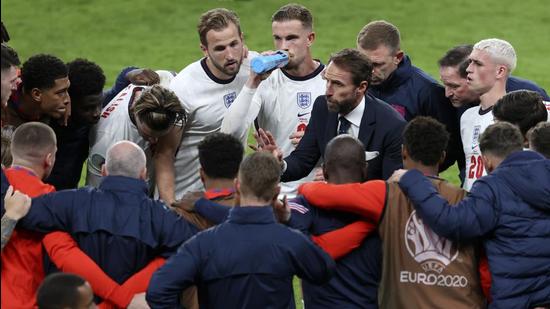 England's manager Gareth Southgate talks to the players during the break in extra time during the Euro 2020 semi-final match against Denmark at Wembley stadium. (AP)