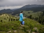 Nazir Ahmed, a healthcare worker, carries vaccines and looks out from a hillock for shepherds to vaccinate them against Covid-19 in Tosamaidan, southwest of Srinagar on June 21. Fueled by misinformation and mistrust, many residents, particularly in remote rural areas, believe that vaccines cause impotence, serious side effects and could even kill. Some simply say they do not need the shots because they’re immune to the coronavirus.(Dar Yasin / AP) Nazir Ahmed, a healthcare worker, carries vaccines and looks out from a hillock for shepherds to vaccinate them against Covid-19 in Tosamaidan, southwest of Srinagar on June 21. Fueled by misinformation and mistrust, many residents, particularly in remote rural areas, believe that vaccines cause impotence, serious side effects and could even kill. Some simply say they do not need the shots because they’re immune to the coronavirus.(Dar Yasin / AP)
