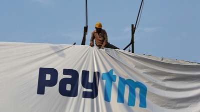A worker adjusts a hoarding of Paytm, a digital payments firm, in Ahmedabad, India, January 31, 2019. (Reuters)