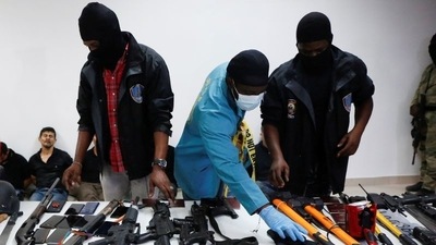 Weaponry, mobile phones, passports and other items along with suspects in the assassination of President Jovenel Moise. (Reuters)