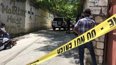 Journalists stand next to a yellow police cordon near the residence of Haiti's President Jovenel Moise. (Reuters)