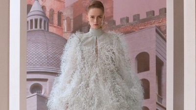 A model wears a  voluminous dress in soft grey was adorned in floating feathers, while other evening looks included sparkly sequined creations. (Instagram)