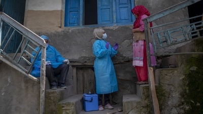 Masrat Farid, a healthcare worker, successfully convinces Kulsuma Banoo to take the Covid-19 vaccine in Gagangeer, northeast of Srinagar on June 22. “Everywhere we go it seems rumours reach earlier than we do, and it makes our job difficult,” Farid told AP during a recent vaccination campaign. (Dar Yasin / AP)