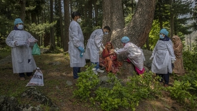 Healthcare workers administering a dose of the Covishield vaccine to Basheera Banoo, a shepherd, during a Covid-19 vaccination drive in the forest area of Gund, northeast of Srinagar on June 22. Apart from the hesitancy, the health workers have faced hostility as well. “There are places where our colleagues have been attacked,” said Farid, who has vaccinated over 800 people so far. (Dar Yasin / AP)