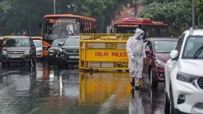 A policeman checks vehicles amid a mild shower at Connaught Place, in New Delhi, Wednesday. (PTI) A policeman checks vehicles amid a mild shower at Connaught Place, in New Delhi, Wednesday. (PTI)