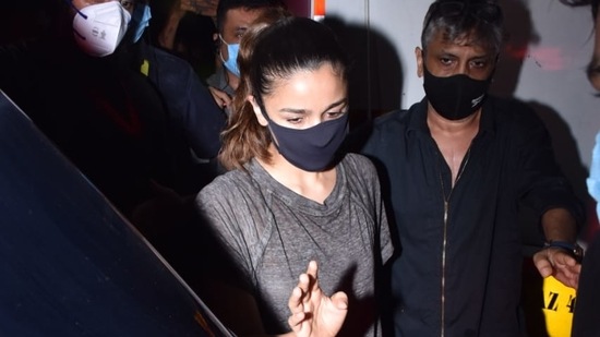 Alia Bhatt avoids the photographers as she makes her way into her car.