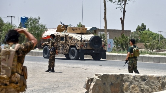 Afghan security personnel stand guard along the road amid ongoing fight between Afghan security forces and Taliban fighters in Kandahar on July 9, 2021. (AFP)