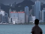 In this file photo taken on June 29, 2021, a man looks at a building with a LED billboard displaying a slogan celebrating the 100th anniversary of the Chinese Communist Party and the 24th anniversary of Hong Kong's return to China. In this file photo taken on June 29, 2021, a man looks at a building with a LED billboard displaying a slogan celebrating the 100th anniversary of the Chinese Communist Party and the 24th anniversary of Hong Kong's return to China.