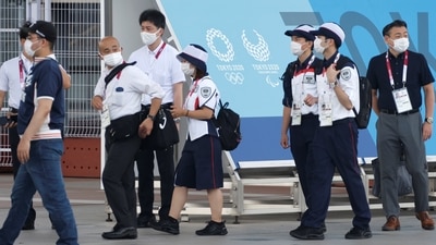 Security personnel are pictured beside a sign advertising the 2020 Tokyo Olympic Games. (REUTERS)