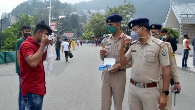 Police personnel warning tourists to wear face masks at Ridge, Shimla on Saturday, (Photo by Deepak Sansta / Hindustan Times) Police personnel warning tourists to wear face masks at Ridge, Shimla on Saturday, (Photo by Deepak Sansta / Hindustan Times)