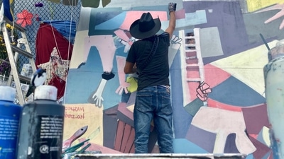 Roberto Marquez used his art to turn Surfside's pain into hope and resilience. (AP Photo/ Stacey Plaisance) Roberto Marquez used his art to turn Surfside's pain into hope and resilience. (AP Photo/ Stacey Plaisance)
