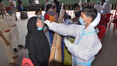 Passengers give their swab samples for Covid-19 tests after arriving at the railway station in Ranchi. (PTI)