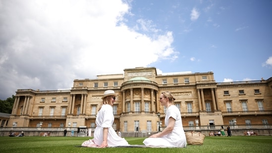 People pose for photographers in The Garden of Buckingham Palace, during a preview day before it opens to the public, in London, Britain, July 8, 2021. (REUTERS)
