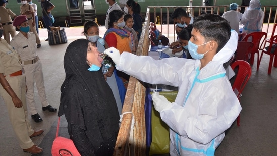 Passengers give their swab samples for Covid-19 tests after arriving at the railway station in Ranchi.(PTI)