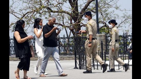 Police personnel asking a family to don masks and follow the Covid-19 protocol at the Ridge in Shimla on Saturday. (Deepak Sansta/HT)