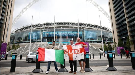 England fans and an Italy fan pose with flags outside Wembley stadium ahead of the Euro 2020 final. (REUTERS)