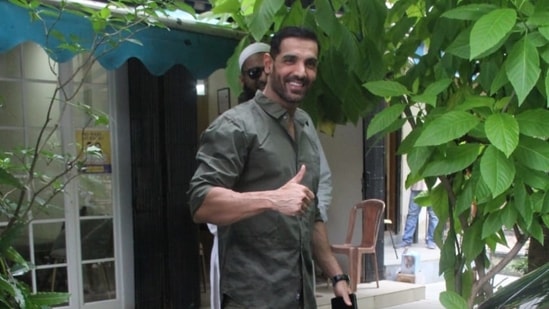 John Abraham shows paparazzi the thumbs up sign.