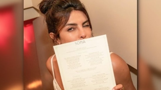 PeeCee posed with the menu of the restaurant that consists of a variety of authentic Indian dishes.(Instagram/@priyankachopra)
