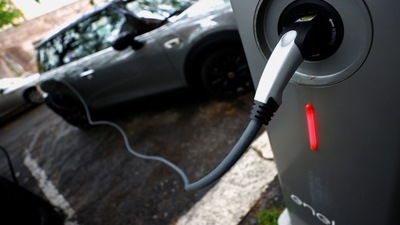 FILE PHOTO: An electric car is seen plugged in at a charging point for electric vehicles. (REUTERS)