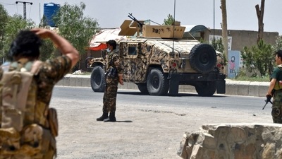 Afghan security personnel stand guard along the road amid ongoing fight between Afghan security forces and Taliban fighters in Kandahar. (AFP) Afghan security personnel stand guard along the road amid ongoing fight between Afghan security forces and Taliban fighters in Kandahar. (AFP)