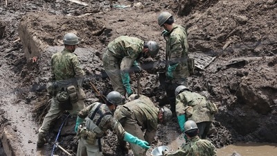 Members of Japan's Self-Defence Forces search for missing people at the scene of a landslide following days of heavy rain in Atami, Shizuoka Prefecture on July 10, 2021. (AFP Photo)