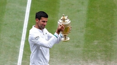 Serbia's Novak Djokovic shows off the winners trophy to the crowd as he walks around Centre Court after defeating Italy's Matteo Berrettini in the men's singles final on day thirteen of the Wimbledon Tennis Championships in London, Sunday, July 11, 2021. (Pete Nichols/Pool Via AP) (AP)