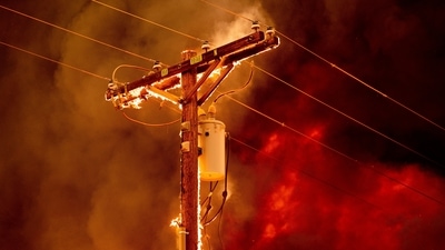 Fire burns along a power pole as the Sugar Fire, part of the Beckwourth Complex Fire, tears through central Doyle, California. (AP file photo) Fire burns along a power pole as the Sugar Fire, part of the Beckwourth Complex Fire, tears through central Doyle, California. (AP file photo)