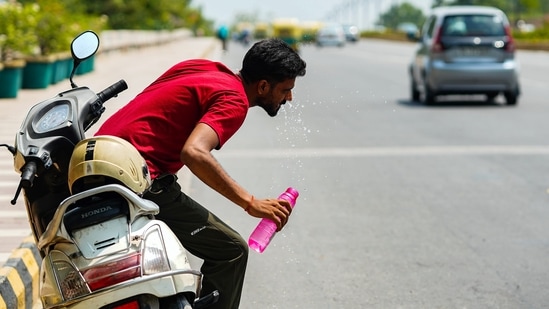 A man washes his face to cope with the heat at Safdarjung flyover, in New Delhi on Saturday.(ANI Photo)