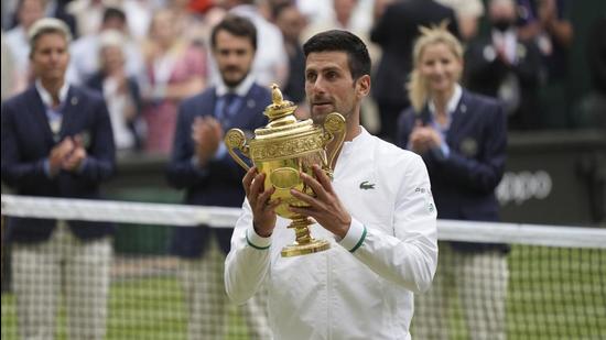 Serbia's Novak Djokovic holds his winner's trophy and celebrates his victory over Italy's Matteo Berrettini after the Wimbledon final in London on Sunday. (AP)