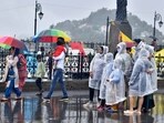 Shimla, India July 12: Tourists in raincoats and others walking with umbrellas during the rain at Ridge, Shimla, Himachal Pradesh, India on Monday, July 12, 2021.(Photo by Deepak Sansta / Hindustan Times)
