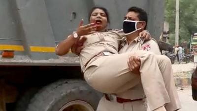 A cop taking the injured SHO to safety during the protest on Rahon Road in Ludhiana on Monday. (HT PHOTO)