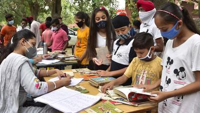 Teachers issuing books to students during the Library Langar programme organised at Government Smart School, PAU, in Ludhiana on Monday. (Harsimar Pal Singh/HT)