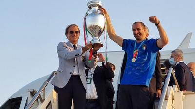Italy coach Roberto Mancini (L) and Giorgio Chiellini holding the European Championship trophy after they won the UEFA EURO 2020 final against England, as they arrive at Rome's Fiumicino airport. (AFP) Italy coach Roberto Mancini (L) and Giorgio Chiellini holding the European Championship trophy after they won the UEFA EURO 2020 final against England, as they arrive at Rome's Fiumicino airport. (AFP)