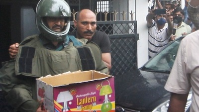 ATS personnel carry explosives recovered after arresting two accused allegedly linked with Al-Qaeda module, in Lucknow on Sunday. (PTI Photo)