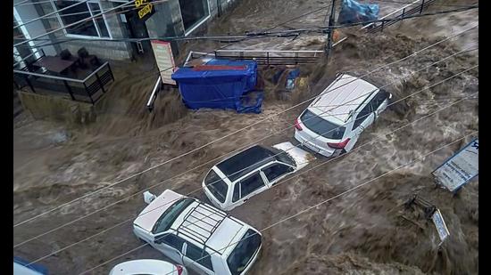 Vehicles trapped in flood water due to heavy rain after a cloudburst, at Mcleodganj near Dharamshala, Monday. (PTI)