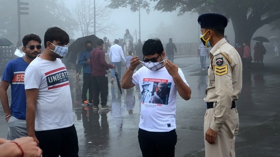 Police personnel directing visitors to wear face masks while strolling in public places, in Shimla on July 11. Visuals from tourist destinations point out violations of Covid-appropriate behaviour, with people not wearing masks or ensuring social distancing.(Deepak Sansta / HT Photo)
