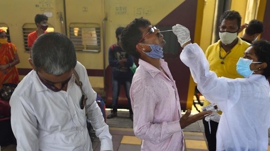 A BMC health worker collects swab samples for Covid-19 test of passengers arriving from outstation trains at Dadar station in Mumbai on July 2. (HT file) A BMC health worker collects swab samples for Covid-19 test of passengers arriving from outstation trains at Dadar station in Mumbai on July 2. (HT file)