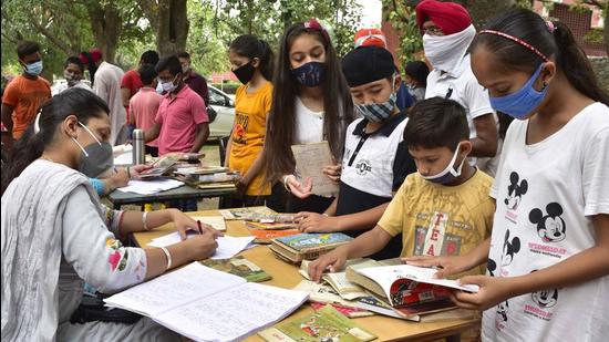 Teachers issuing books to students during the Library Langar programme organised at Government Smart School, PAU, in Ludhiana on Monday. (Harsimar Pal Singh/HT)