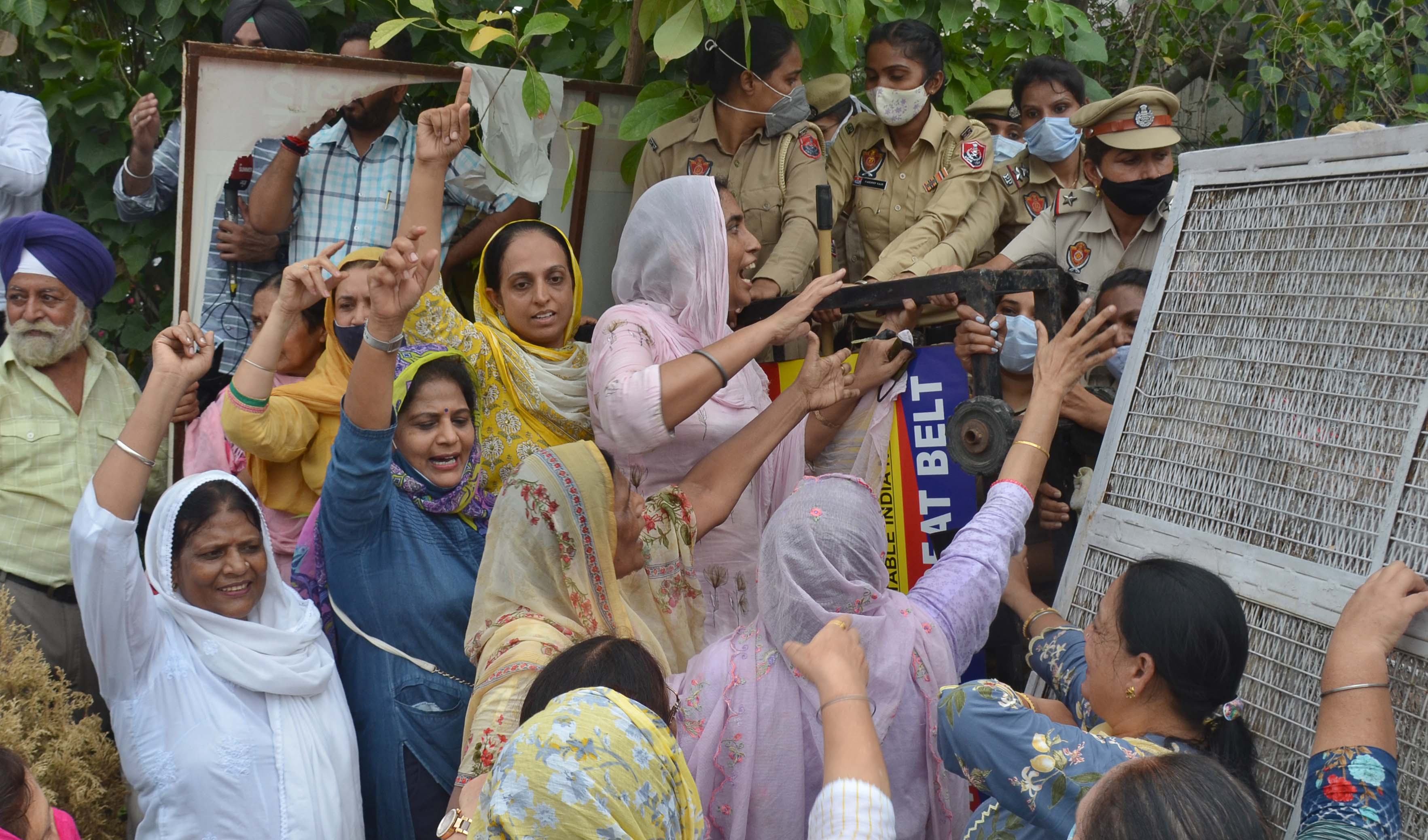 SAD women wing members trying to jump the barricades installed outside the DC office in Ludhiana on Monday. (Gurpreet Singh/HT) SAD women wing members trying to jump the barricades installed outside the DC office in Ludhiana on Monday. (Gurpreet Singh/HT)