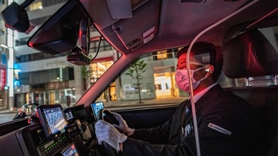 Taxi driver Yuki Kawaguchi driving in the Ginza district in Tokyo on July 7. In his white gloves, dark suit and tie, taxi driver Yuki Kawaguchi is ready to ferry passengers around Tokyo in style. (Philip Fong / AFP) Taxi driver Yuki Kawaguchi driving in the Ginza district in Tokyo on July 7. In his white gloves, dark suit and tie, taxi driver Yuki Kawaguchi is ready to ferry passengers around Tokyo in style. (Philip Fong / AFP)