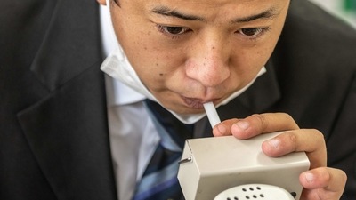 Yuki Kawaguchi conducting an alcohol level check at the Shinagawa office of his employer Nihon Kotsu company in Tokyo on July 7. After changing into his smart uniform, he takes a breathalyser test and a temperature check, then enters his gleaming black taxi adorned with the logo of the virus-postponed 2020 Games. (Philip Fong / AFP) Yuki Kawaguchi conducting an alcohol level check at the Shinagawa office of his employer Nihon Kotsu company in Tokyo on July 7. After changing into his smart uniform, he takes a breathalyser test and a temperature check, then enters his gleaming black taxi adorned with the logo of the virus-postponed 2020 Games. (Philip Fong / AFP)
