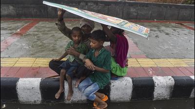A family covers themselves under a hoarding during the rain as monsoon reaches New Delhi, Tuesday. (PTI) A family covers themselves under a hoarding during the rain as monsoon reaches New Delhi, Tuesday. (PTI)