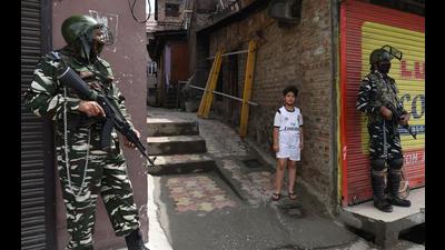 Armed soldiers stand guard as a Kashmiri boy looks on near martyrs’ graveyard in Srinagar on Tuesday. (Waseem Andrabi/Hindustan Times) Armed soldiers stand guard as a Kashmiri boy looks on near martyrs’ graveyard in Srinagar on Tuesday. (Waseem Andrabi/Hindustan Times)