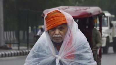 A man covers himself with a plastic sheet while rising a bicycle during rain. (PTI) A man covers himself with a plastic sheet while rising a bicycle during rain. (PTI)