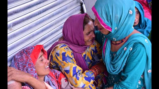 Women grieve for their dead relatives in a landslide after heavy rains at Boh village in Kangra district on Tuesday (HT Photo)