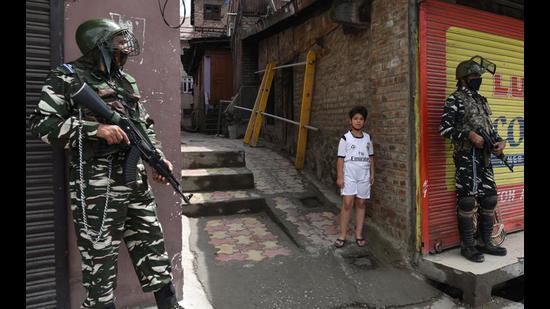 Armed soldiers stand guard as a Kashmiri boy looks on near martyrs’ graveyard in Srinagar on Tuesday. (Waseem Andrabi/Hindustan Times) Armed soldiers stand guard as a Kashmiri boy looks on near martyrs’ graveyard in Srinagar on Tuesday. (Waseem Andrabi/Hindustan Times)